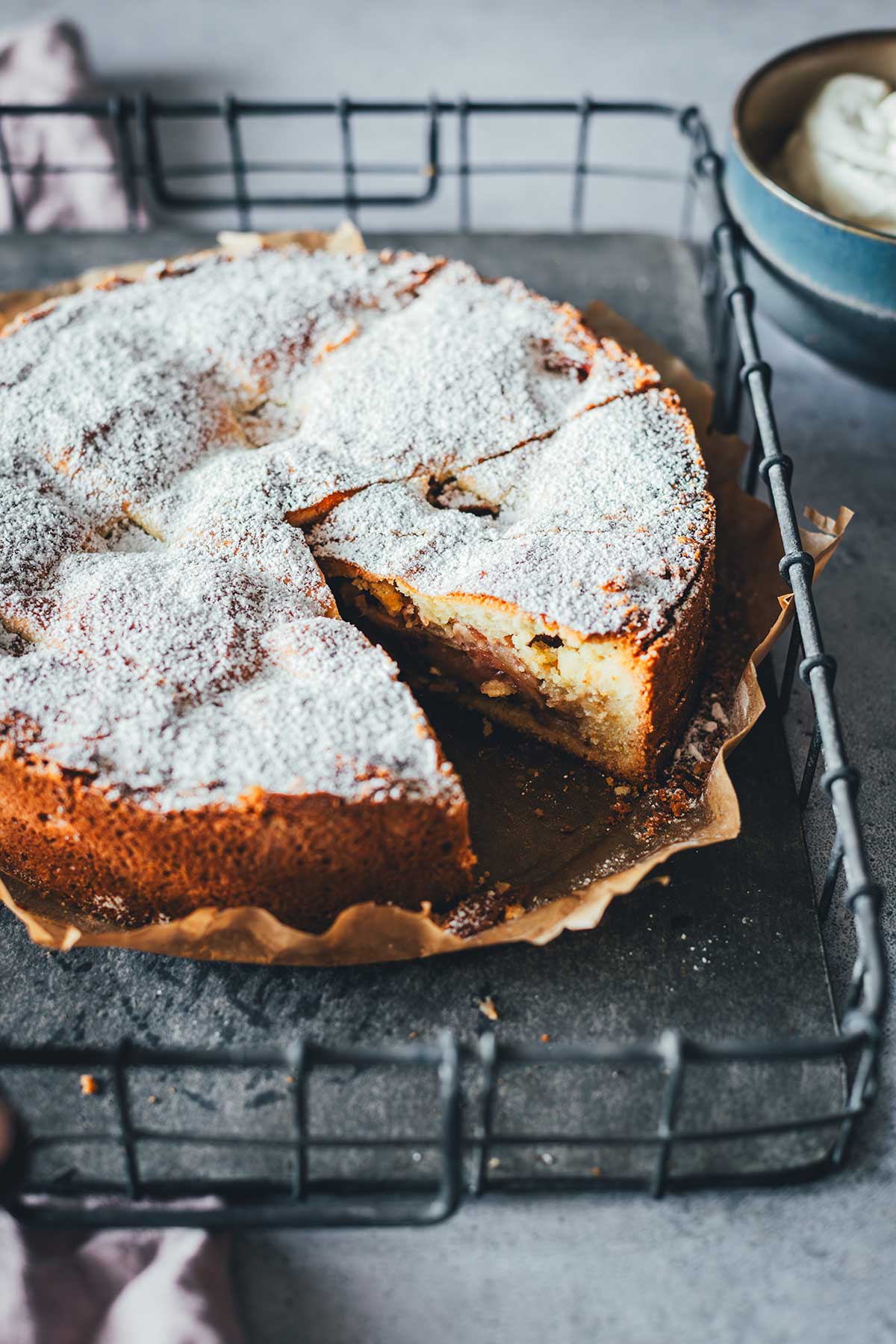 Seitlich angeschnittene Appeltaart, mit Puderzucker bestreut und auf einem Tablett serviert | moeyskitchen.com