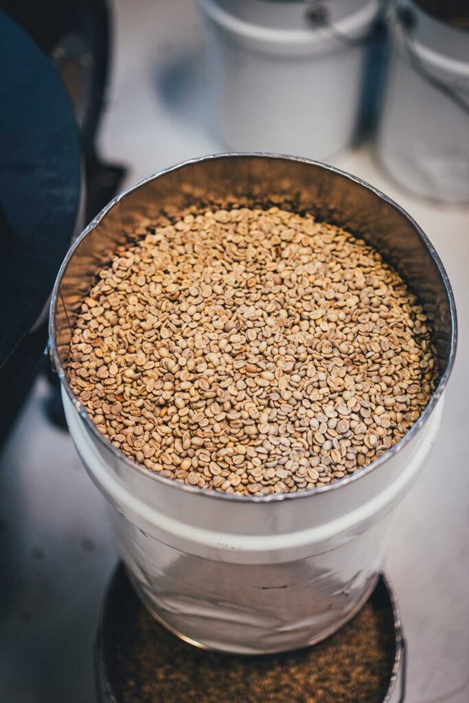 Rohe grüne Kaffeebohnen in einer Tonne vor dem Rösten | moeyskitchen.com