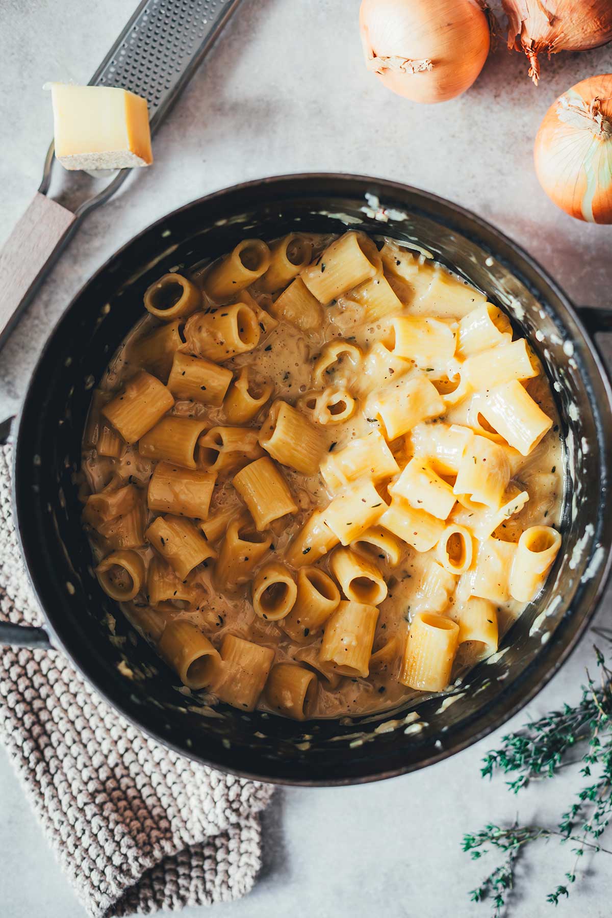 Topshot in einen gusseisernen Topf, gefüllt mit kurzer Pasta mit Zwiebeln in einer cremigen Sauce | moeyskitchen.com