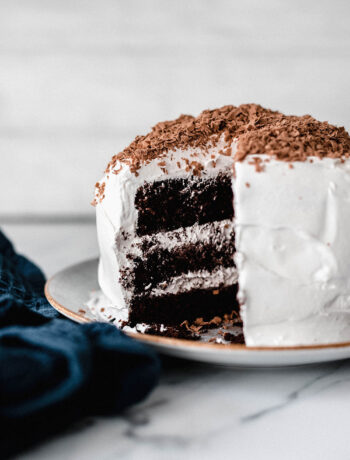 Schokoladiger Devils Food Cake mit heller Cremefüllung, angeschnitten auf einer Tortenplatte