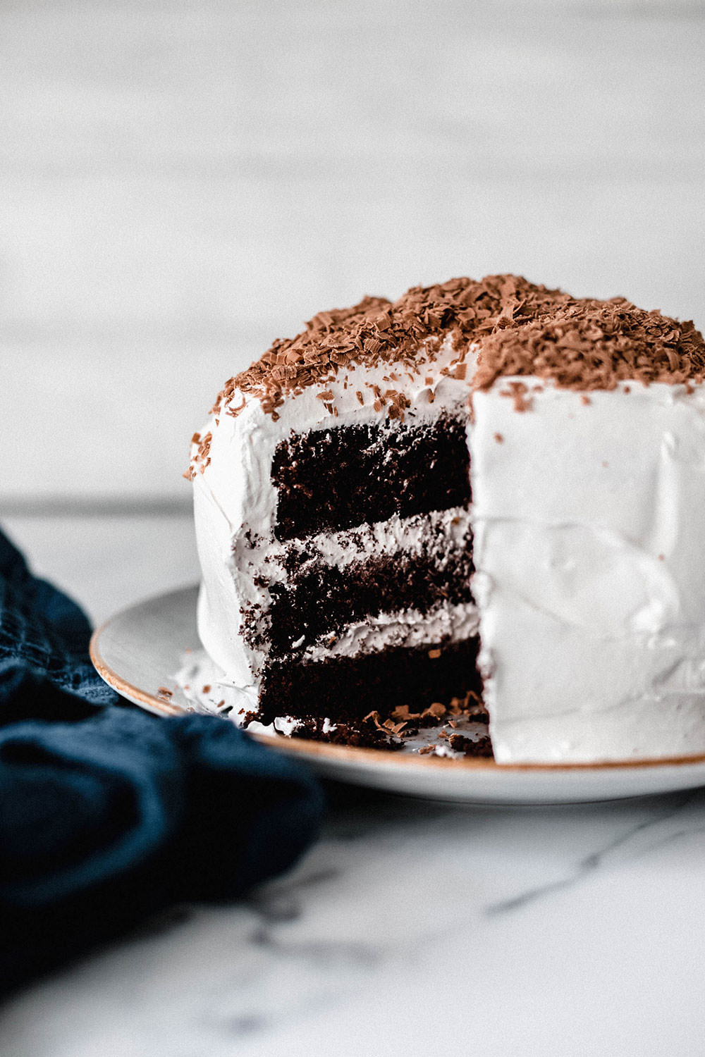 Schokoladiger Devils Food Cake mit heller Cremefüllung, angeschnitten auf einer Tortenplatte