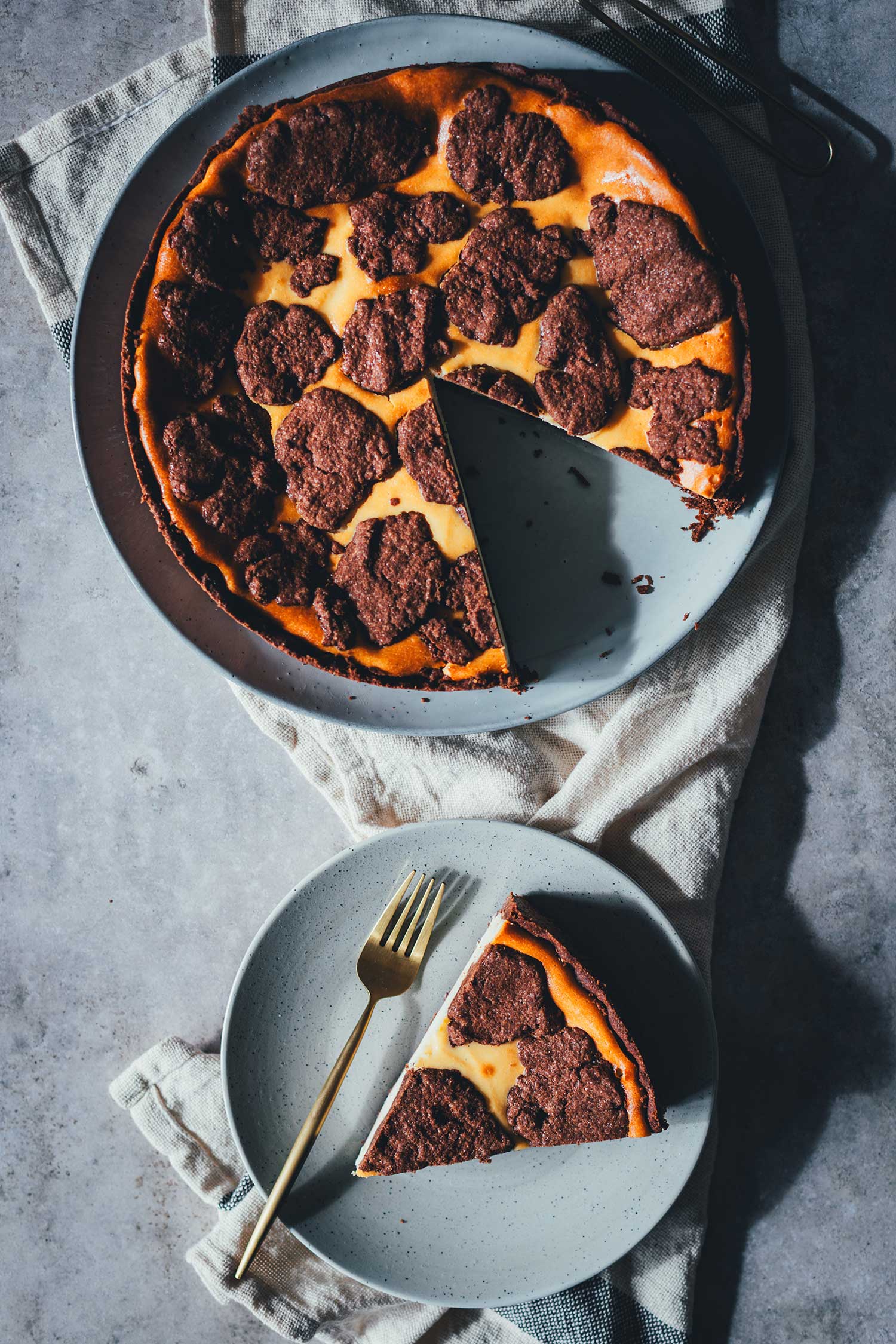 Topshot vom russischen Zupfkuchen als runder Kuchen auf Kuchenplatte, mit einem herausgeschnittenen Stück auf Teller