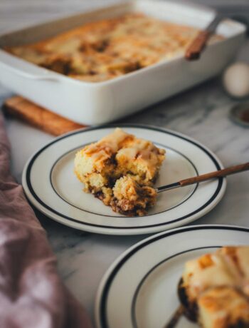 Zimtschnecken-Kuchen-ohne Hefe, serviert als Kuchenstücke auf Tellern. Man sieht, wie saftig und fluffig der Teig ist. Im Hintergrund steht die Backform.