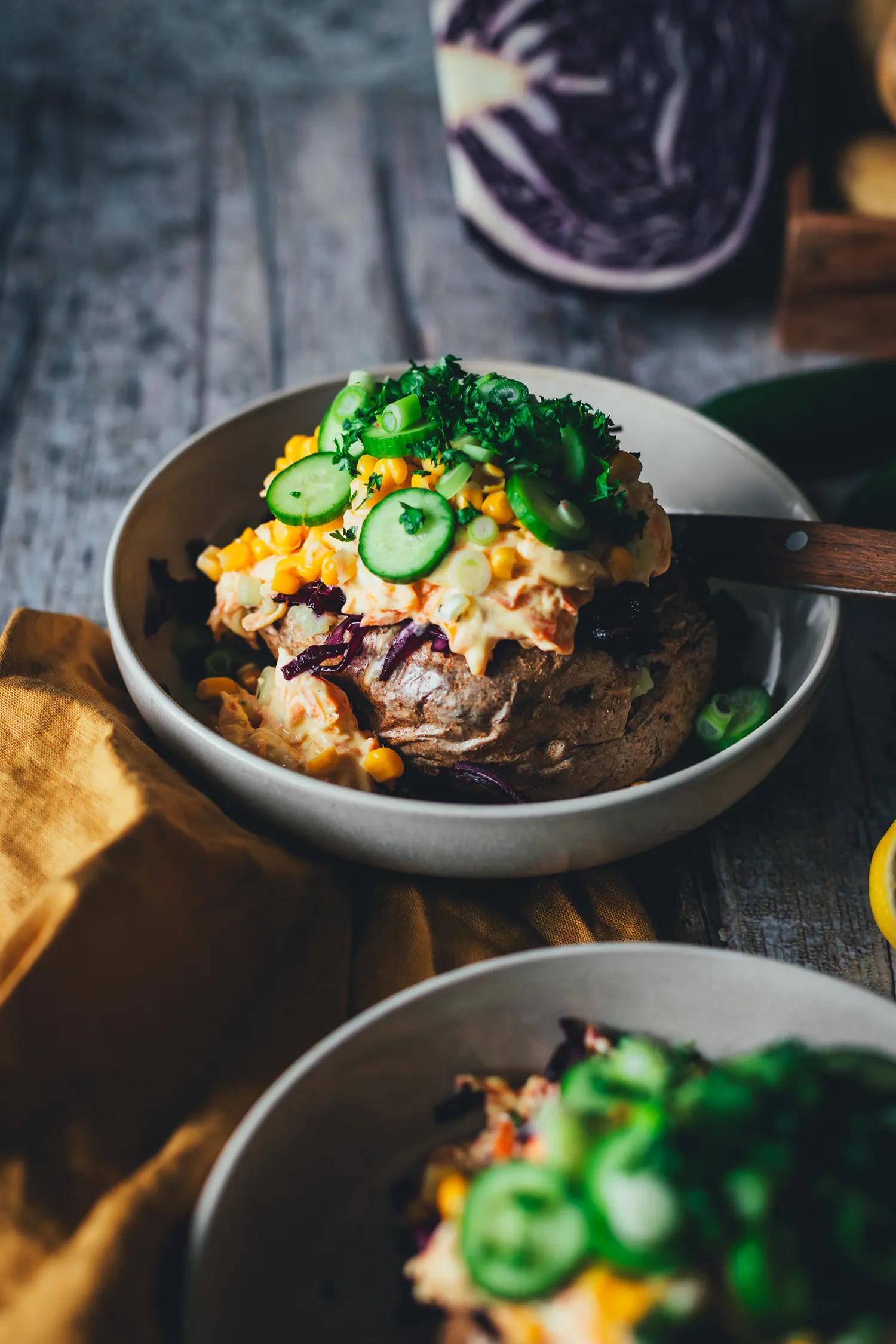 Kumpir-Backkartoffel mit üppigem Topping aus Mais, Rotkohl, Möhren-Joghurt und Gurke in der Nahaufnahme
