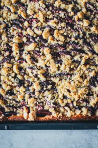 Fertig gebackener Zweitschgenkuchen mit Hefeteig und knusprigen Streuseln auf dem Backblech.